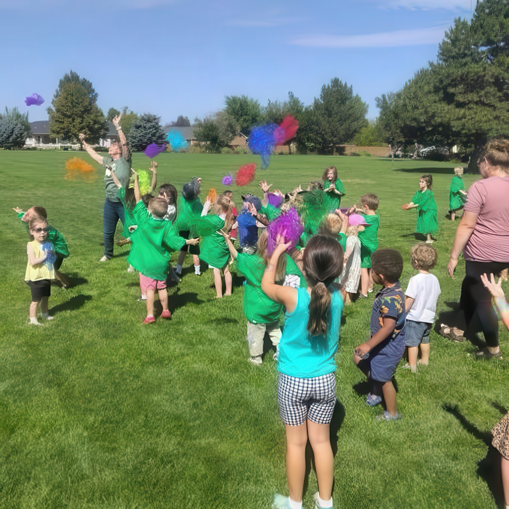 Large group of children outdoors tossing colorful scarves.
