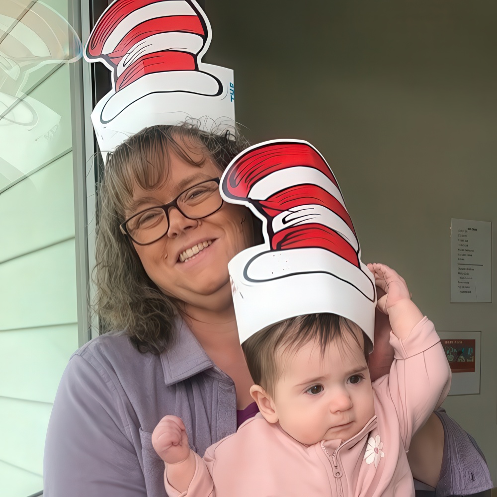 Teacher and baby wearing matching Cat in the Hat paper hats.