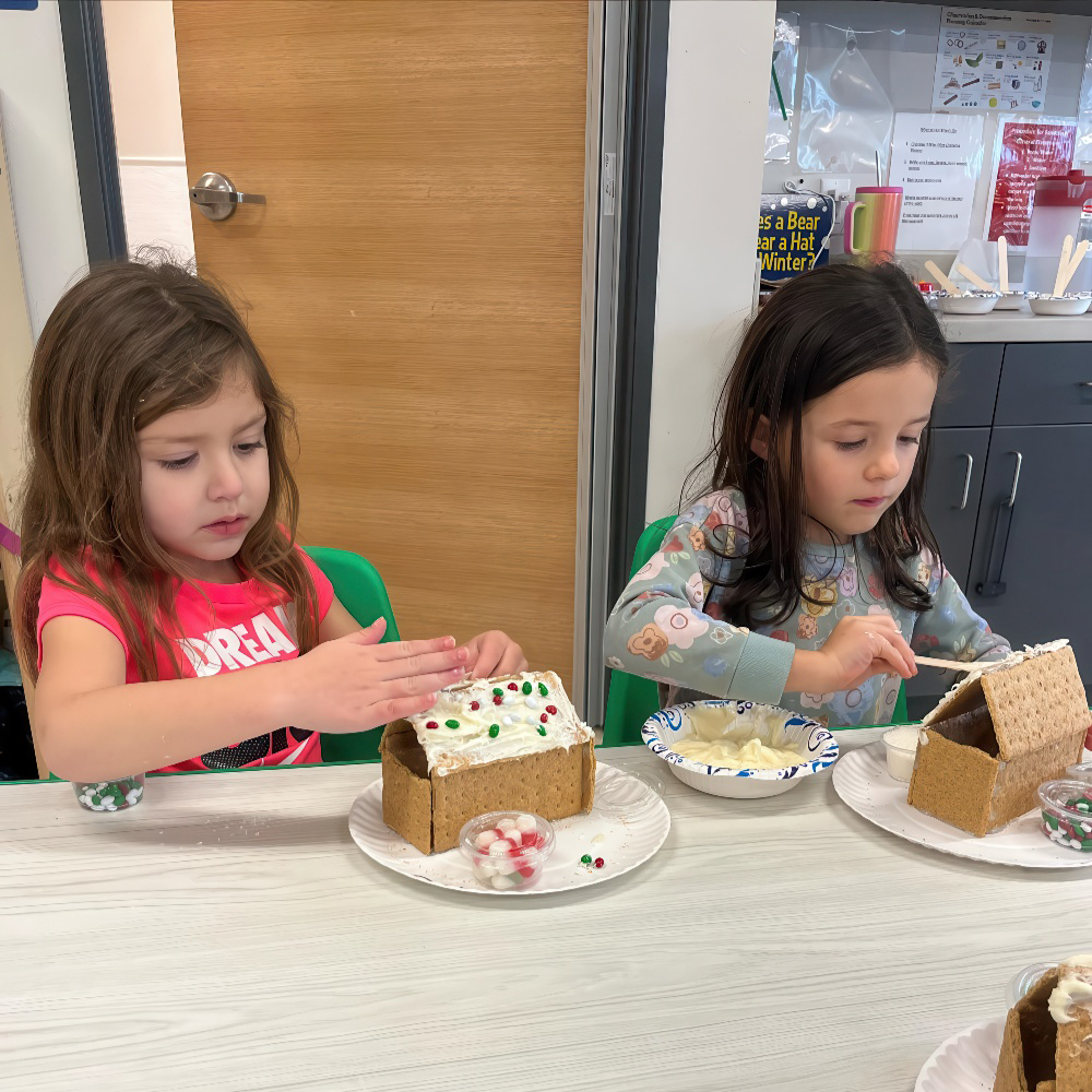 Kids decorate gingerbread houses with frosting and candy.