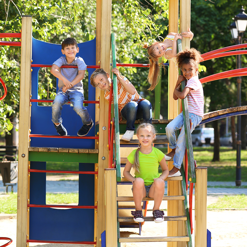 Group of kids climbing and playing on outdoor playground.