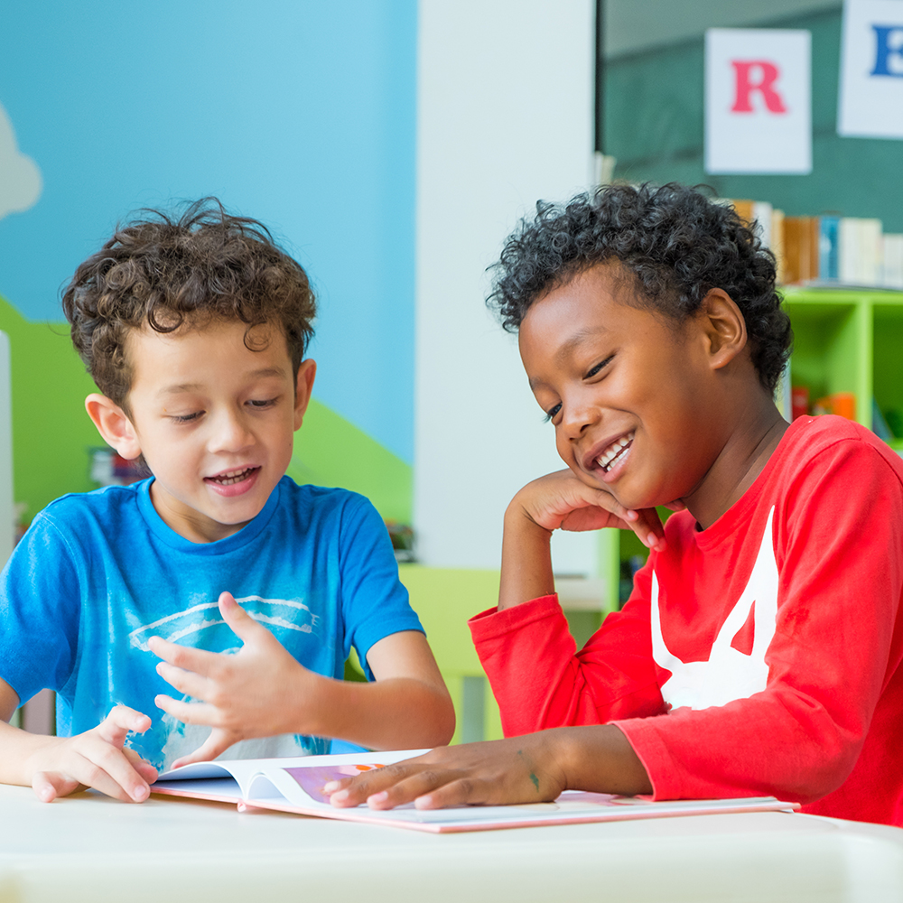 Two children read and share ideas together in class.